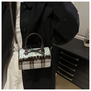 Detailed view of stars and plaid patterns on the ruffled cylindrical crossbody bag