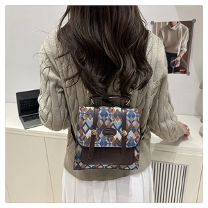 Detail of vintage diamond pattern textile and brown leather backpack on model
