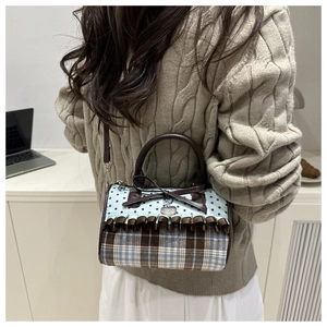 Détail du sac à main à nœud avec motif à carreaux bleus et bordure en dentelle