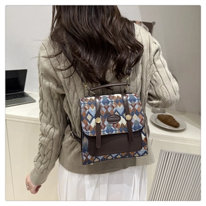 Detail of a geometric jacquard backpack with leather straps used in a casual setting