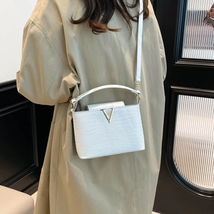 White woven leather crossbody bag with V-shaped gold hardware and minimalist design