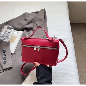 Macro shot of red pebble leather handbag with silver heart-shaped zipper pullers