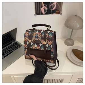 Detail of vintage geometric jacquard backpack with leather straps on a white desk