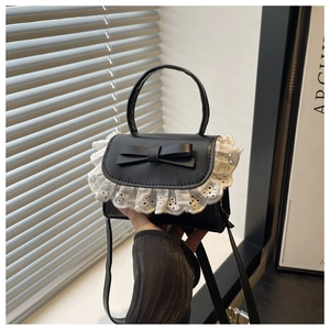 Detail of black leather handbag with white lace trim and bow for a sweet lolita style