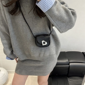 Petit sac carré en cuir noir avec boucle cœur argentée porté en bandoulière