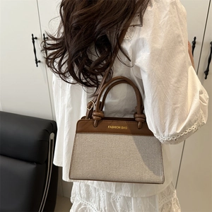 Retro canvas and brown leather crossbody bag held by model in white lace dress