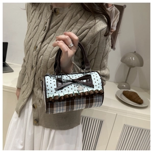 Vue détaillée d'un sac Boston à nœud papillon avec motifs étoiles et tissu écossais
