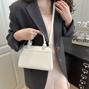 White faux leather crossbody bag with knot handle and gold FASHION BAG lettering