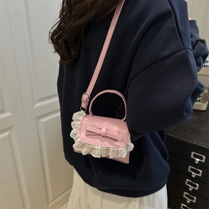 Pink crossbody bag with bow and lace trim shown on model for a trendy casual look