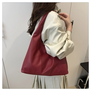 Detail of red pebbled leather tote bag showing large capacity and hobo silhouette on model