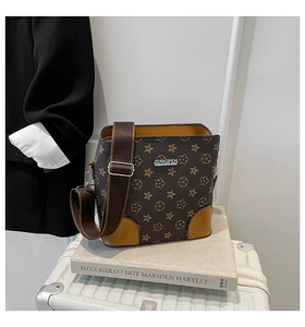 Detail of vintage brown shoulder bag with monogram texture and yellow leather corners