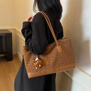 Retro leopard print tote bag with brown leather straps and cute plush monster charm