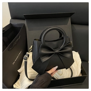 Detail of black matte leather shoulder bag with bow knot in luxury gift box set