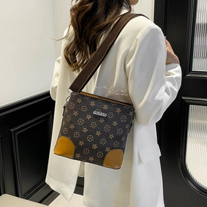 Brown leather crossbody bucket bag with star pattern and wide strap on white blazer model