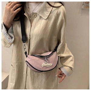 Pink saddle bag close-up showing suede texture, white letter embroidery and metal zippers