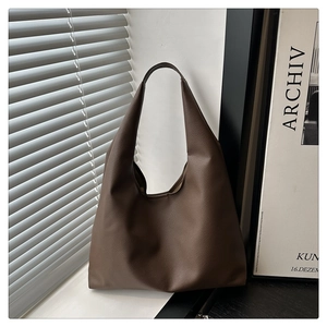 Detailed view of dark brown pebbled leather hobo shoulder bag with natural light shadows