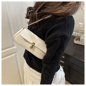 White faux crocodile skin shoulder bag shown worn by a model in a minimalist interior