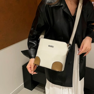 White bucket shoulder bag with brown leather trim and wide strap for women