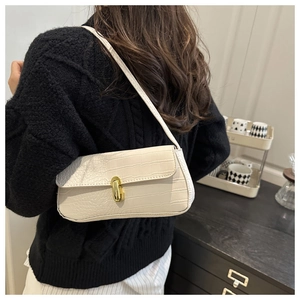 Chic beige crocodile pattern underarm bag shown on shoulder with golden oval buckle clasp