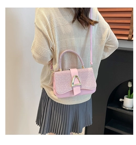 Detailed view of pink sequin crossbody bag with gold triangle buckle on model