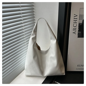 Detail of white leather hobo bag with minimalist design and integrated wide handle