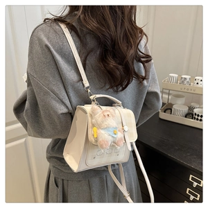 Detail of cream white PU crossbody bag with cartoon illustration and plush bunny charm