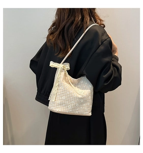 Détail du sac bandoulière en toile à broderie marguerite et grand nœud en dentelle
