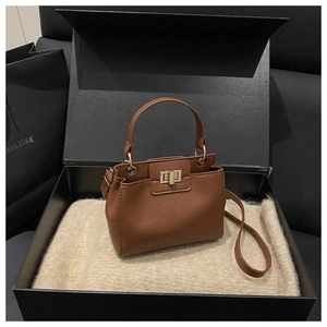 Detailed macro view of brown lychee grain leather bucket bag with gold square clasp