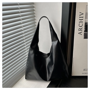 Minimalist black hobo shoulder bag featuring premium leather texture and a wide strap design