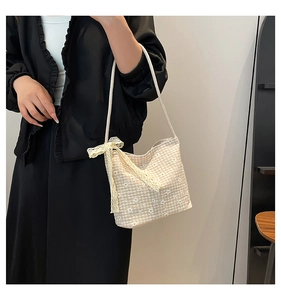 Détail d'un sac seau en vichy avec imprimés marguerites et nœud décoratif en dentelle