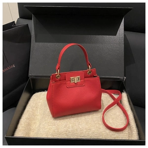 Detail of red lychee grain leather bucket bag with gold clasp in premium gift box set