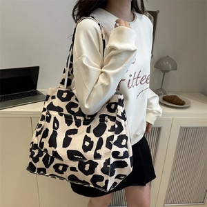 Chic leopard print large capacity tote bag with front pocket carried by a model