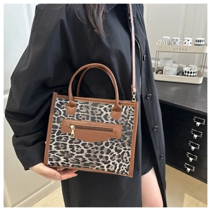 Close-up of leopard print tote bag with brown PU straps and front zipper detail