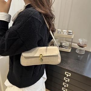 Beige crocodile embossed baguette bag with golden swivel lock and minimalist shoulder strap