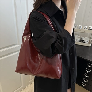 Minimalist glossy burgundy patent leather tote bag for women showing Hobo style silhouette