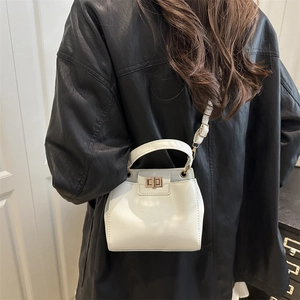 Chic white lychee leather bucket bag with top handle and gold twist lock shown on model