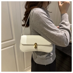 Close-up of white lychee pattern leather baguette bag featuring a gold vertical metal lock