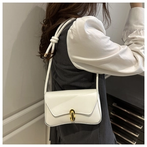 Détail du sac bandoulière blanc avec fermoir pivotant doré et sangle à nœuds décoratifs