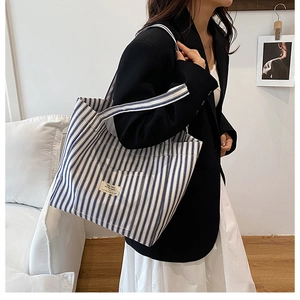 Lifestyle shot of large capacity blue and white vertical striped canvas tote bag