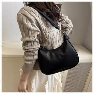 Classic black hobo shoulder bag styled with a beige sweater and white skirt outfit