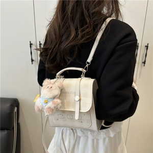 Chic beige plaid backpack with bear motif and plush charm, shown on model back