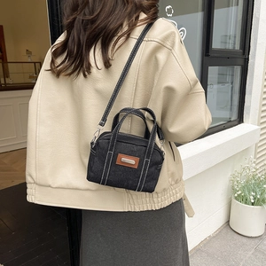 Black denim crossbody bag with contrast stitching and metal logo in casual fashion style