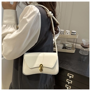 Sac bandoulière blanc minimaliste avec rabat ondulé et boucle dorée porté par mannequin