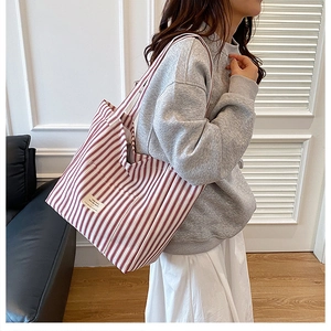 Close-up of red and white striped tote bag with durable canvas texture and side label