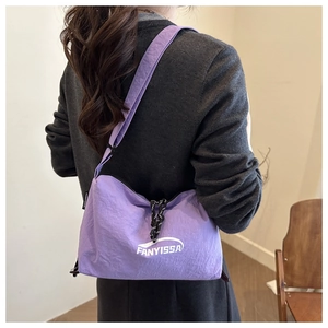 Detail view of purple nylon crossbody bag with logo and soft wrinkled fabric texture