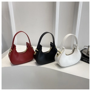 Three minimalist crescent mini handbags in red, black, and white with golden hardware