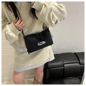 Minimalist black nylon crossbody bag with FANYISSA text shown in a stylish lifestyle setting