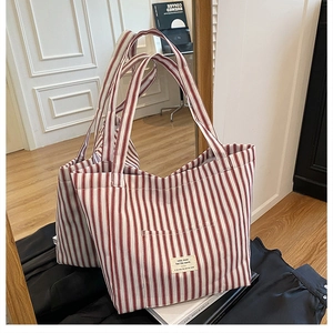 Close-up of a red and white striped canvas tote bag with a front pocket detail