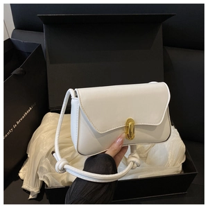 Détail d'un sac à rabat blanc avec fermoir capsule doré et bandoulière en corde fine