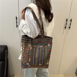 Bohemian woven tote bag with colorful geometric patterns and wide shoulder strap for women